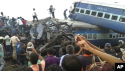 Railway police and local volunteers look for survivors in the upturned coaches of the Kalinga-Utkal Express after an accident near Khatauli, in the northern Indian state of Uttar Pradesh, Aug. 19, 2017.