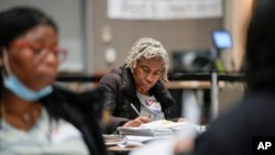 Workers count absentee ballots at the Wisconsin Center for the midterm election, Nov. 8, 2022, in Milwaukee. 