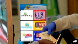 A customer is handed Powerball tickets purchased at Lichine's Liquor & Deli in Sacramento, Calif., Nov. 7, 2022. 