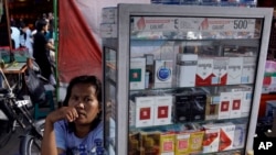 Seorang pemilik warung rokok sedang menunggu pembeli di Medan, Sumatra Utara, 10 Januari 2013. (Foto: Binsar Bakkara/AP Photo)