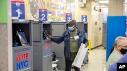 A poll worker prints a ballot from a Board of Elections printing machine at an early voting polling site at Frank McCourt High School in New York, Nov. 1, 2022.
