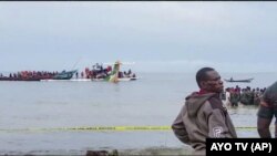 Rescatistas en botes se ven en torno a la cola de un avión de pasajeros de Precision Air en el Lago Victoria, en Bukoba, en el oeste de Tanzania, el domingo 6 de noviembre de 2022.