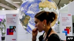 A participant walks past a mockup of the planet Earth globe at the Sharm el-Sheikh International Convention Centre, on the first day of the COP27 climate summit, in Egypt's Red Sea resort city of Sharm el-Sheikh, Nov. 6, 2022. 