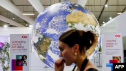 A participant walks past a mockup of the planet Earth globe at the Sharm el-Sheikh International Convention Centre, on the first day of the COP27 climate summit, in Egypt's Red Sea resort city of Sharm el-Sheikh, Nov. 6, 2022.