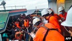 Awak kapal 'Helios Leader' berbendera Jepang menyelamatkan para migran yang dicurigai dari Sri Lanka di atas kapal penangkap ikan 'Lady 3' berbendera Myanmar sekitar 250 mil dari Vung Tau di pantai selatan Vietnam, 8 November 2022 (Doan Minh Duong / Kantor Berita Vietnam / AFP)