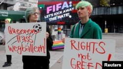 Participants display placards as LGBT+ associations protest in front of FIFA World Football Museum, as Qatar is set to host the 2022 World Cup, in Zurich, Switzerland, Nov. 8, 2022. 