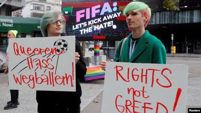 Participants display placards as LGBT+ associations protest in front of FIFA World Football Museum, as Qatar is set to host the 2022 World Cup, in Zurich, Switzerland, Nov. 8, 2022.