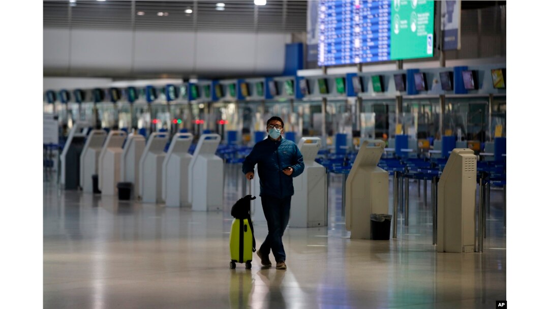 Seorang penumpang yang memakai masker untuk mencegah penyebaran virus corona baru, berjalan di Bandara Internasional Eleftherios Venizelos yang kosong di Athena, Kamis, 15 Oktober 2020. (Foto: AP)