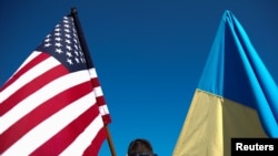 Чоловік тримає прапори США та України під час мітингу «Стоїмо з Україною» проти російського вторгнення в Україну перед Білим домом у Вашингтоні, США, 28 лютого 2022 року