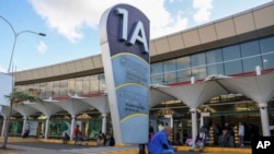 People wait outside the Jomo Kenyatta International Airport in Nairobi, Kenya, on Monday during the Kenya Airways pilots strike. Flights resumed Wednesday after a court order ended the walkout.
