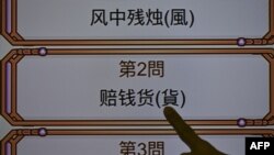 Seorang pria menunjuk huruf tradisional China di sebelah karakter sederhana dalam wawancara di Taipei, 2 November 2017. (SAM YEH / AFP) 