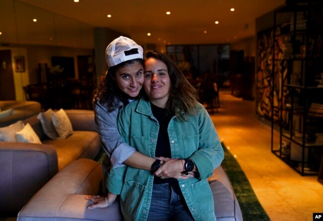 Saskia Nino de Rivera, right, a Mexican civil rights activist, and her girlfriend Mariel Duayhe, a sports agent for Mexican soccer players, pose for a photo at their apartment in Mexico City, Nov. 8, 2022.