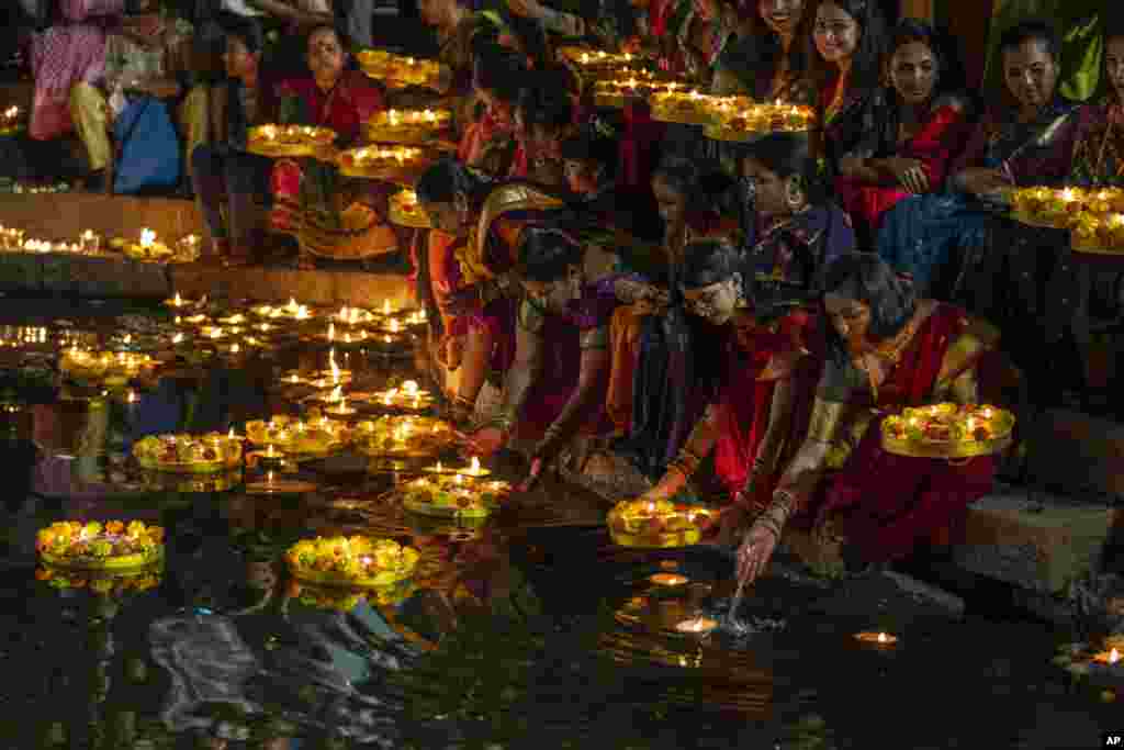 Hindu women light oil lamps at the Banganga pond as they celebrate Dev Diwali festival in Mumbai, India.