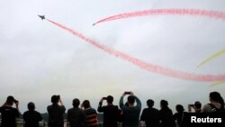 People watch the Bayi aerobatic team of the Chinese People's Liberation Army Air Force perform at the China International Aviation and Aerospace Exhibition, or Airshow China, in Zhuhai, Guangdong province, China, Nov. 8, 2022. (China Daily via Reuters)