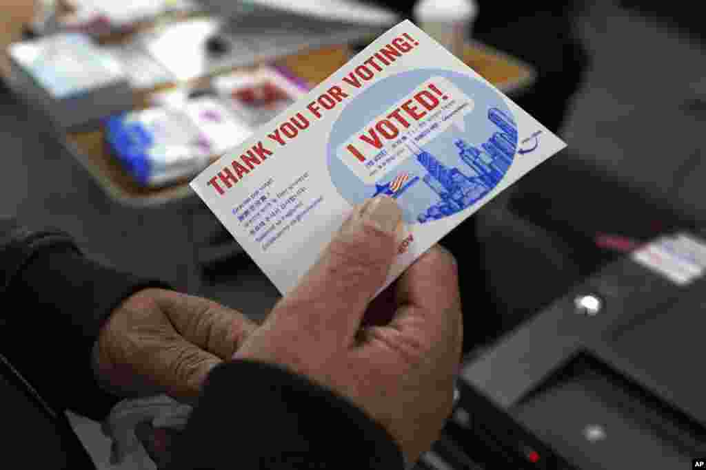 A voter receives his I Voted card after casting his ballot at the Su Nueva Lavanderia near Chicago's Midway Airport, Nov. 8, 2022, in Chicago, Illinois. 