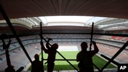 FILE - Laborers remove scaffolding at the Al Bayt stadium in Al Khor, Qatar, about 50 kilometers (30 miles) north of Doha, Apr. 29, 2019. 