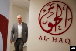 FILE - Shawan Jabarin, director of the Al-Haq human rights group, walks through the organization's offices in the West Bank city of Ramallah, Oct. 23, 2021