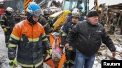 Spasioci evakuišu tijelo civila poginulog u ruskom raketnom udaru na zgradu u kojoj je živio, u gradu Zmijiev, u regionu Harkova, Ukrajina, 8. januara 2024.