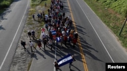 Central American migrants, part of a caravan trying to reach the U.S., walk along the road as they continue their journey, in Ciudad Hidalgo, Mexico, Oct. 26, 2018. 