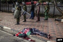 The Kenyan flag covers a body after demonstrators stormed the Kenyan parliament building during a protest in Nairobi against tax hikes, June 25, 2024.