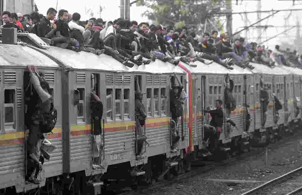 Penumpang berjubel di dalam KRL Jakarta-Bogor, sementara sebagian yang nekat menumpang di atap. Ini merupakan pemandangan yang rutin terlihat setiap jam sibuk.