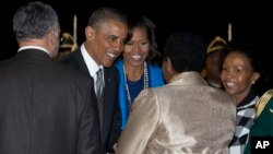President Barack Obama and first lady Michelle Obama are greeted upon their arrival at Waterkloof Air Base in Centurion, South Africa, June 28, 2013,.