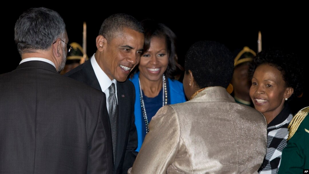 Presiden Obama and Michelle Obama disambut saat kedatangan mereka di Pangkalan Udara Waterkloof di Centurion, Afrika Selatan (28/6). Kunjungan Obama dibayangi oleh kesehatan Mandela yang memburuk.
