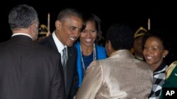 Presiden Obama and Michelle Obama disambut saat kedatangan mereka di Pangkalan Udara Waterkloof di Centurion, Afrika Selatan (28/6). Kunjungan Obama dibayangi oleh kesehatan Mandela yang memburuk.