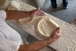 Bakers prepare the dough with ingredients provided by families to prepare and bake special pitta bread called in Albanian (pitalka) for Iftar during the holy month of Ramadan in southern Kosovo city of Prizren on Friday, June 17, 2016. (AP Photo)