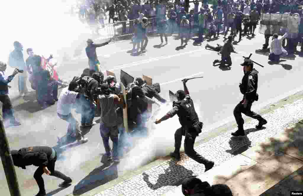 Demonstrators clash with riot police during a protest as they try to approach a military parade on Brazil&#39;s Independence Day in Rio de Janeiro. The protesters called on the government to provide better security, education, health and public services.