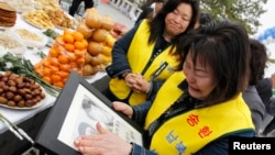 지난 2011년 4월 비무장 지대 인근 임진각에서 납북 희생자 추모 행사가 열린 가운데, 한국의 납북자 가족이 사진을 들고 울고 있다. (자료사진)
