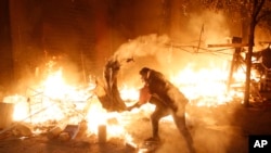 یکی از معترضان لبنانی در حال تلاش برای خاموش کردن آتش در بیروت - شنبه ۲۸ دی 