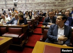Greek Prime Minister Alexis Tsipras (R) is seen before a ruling Syriza party parliamentary group session in Athens, Greece July 15, 2015.