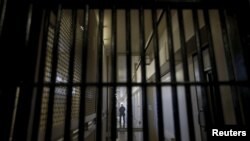 FILE - A guard stands behind bars at a prison, Dec. 29, 2015.