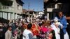 Seorang pria Muslim Bulgaria menggendong putranya di atas kuda saat mereka menghadiri ritual menjelang upacara sunat massal di Desa Ribnovo, Bulgaria, 11 April 2021. (Foto: REUTERS/Stoyan Nenov)