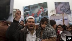 An Afghan man and his son take part in a protest in Kabul, March 6, 2011