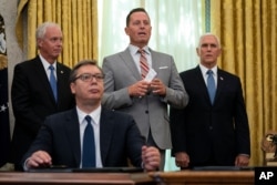 FILE - President Donald Trump’s special envoy on Serbia and Kosovo Richard Grenell speaks during a signing ceremony with Serbian President Aleksandar Vucic sitting at a desk in the Oval Office of the White House in Washington, Sept. 4, 2020.