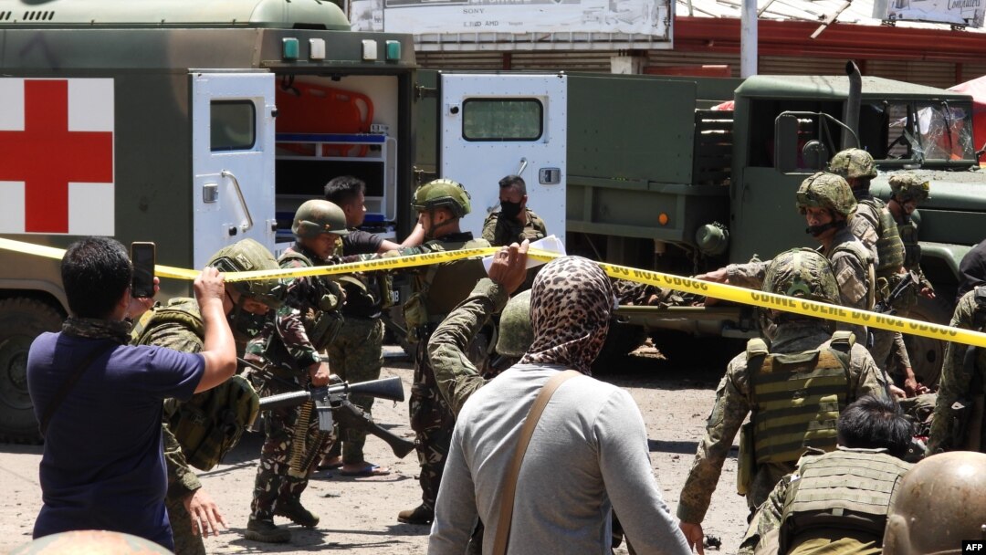 Sejumlah tentara menggotong seorang pria meninggalkan lokasi ledakan yang tidak jauh dari sebuah truk militer di kota Jolo di pulau Sulu, 24 Agustus 2020.