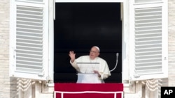 Paus Fransiskus melambaikan tangan saat doa Angelus siang dari jendela studionya yang menghadap ke Lapangan Santo Petrus, di Vatikan, Minggu, 22 September 2024. (Alessandra Tarantino/AP)