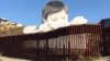 Erigen imagen gigante de niño que se asoma por muro EE.UU.-México 