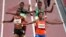 Sifan Hassan, of the Netherlands, foreground right, crosses the finish line ahead of Agnes Tirop, of Kenya, left, to win a heat in the women's 5,000-meter run at the 2020 Summer Olympics, July 30, 2021, in Tokyo. 