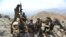FILE - Afghan resistance movement and anti-Taliban forces take a break as they patrol on a hilltop in the Darband area of Anaba district, in Afghanistan's Panjshir province, Sept. 1, 2021.