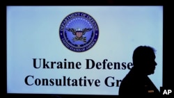 A participant stands in front of a video scree during the meeting of the Ukraine Security Consultative Group at Ramstein Air Base in Ramstein, Germany, April 26, 2022.