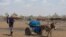 FILE - A woman uses a donkey cart to transport a barrel of water in drought affected areas in Higlo Kebele, Adadle woreda, Somali region of Ethiopia, in this undated handout photograph.