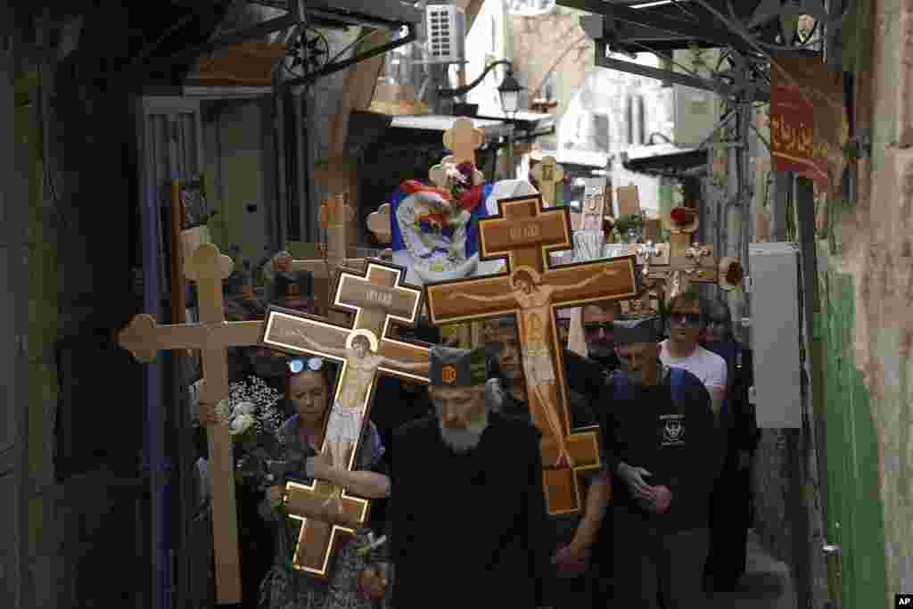 Orthodox worshippers hold crosses as they walk along the Via Dolorosa toward the Church of the Holy Sepulchre, where many Christians believe Jesus was crucified, buried and rose from the dead. (AP Photo/Ariel Schalit)