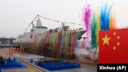 2017年6月28日，新華社發布的資料照片，在上海江南造船廠舉行的下水儀式上，中國新型國產萬噸級055型驅逐艦旁邊燃放煙花。