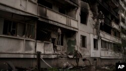 Украинские солдаты исследуют здание после обстрелов российских войск в Харькове, Украина. 24 апреля 2022 г.