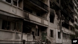 Un militar ucraniano inspecciona un edificio de apartamentos gravemente dañado tras el bombardeo ruso en Kharkiv, Ucrania, el domingo 24 de abril de 2022. (Foto AP/Felipe Dana)