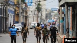 Miembros de las fuerzas de seguridad patrullan una calle en el centro de San Salvador después de que el Congreso de El Salvador extendiera los poderes de emergencia para luchar contra las pandillas por un mes más, en San Salvador, El Salvador, el 25 de abril de 2022.