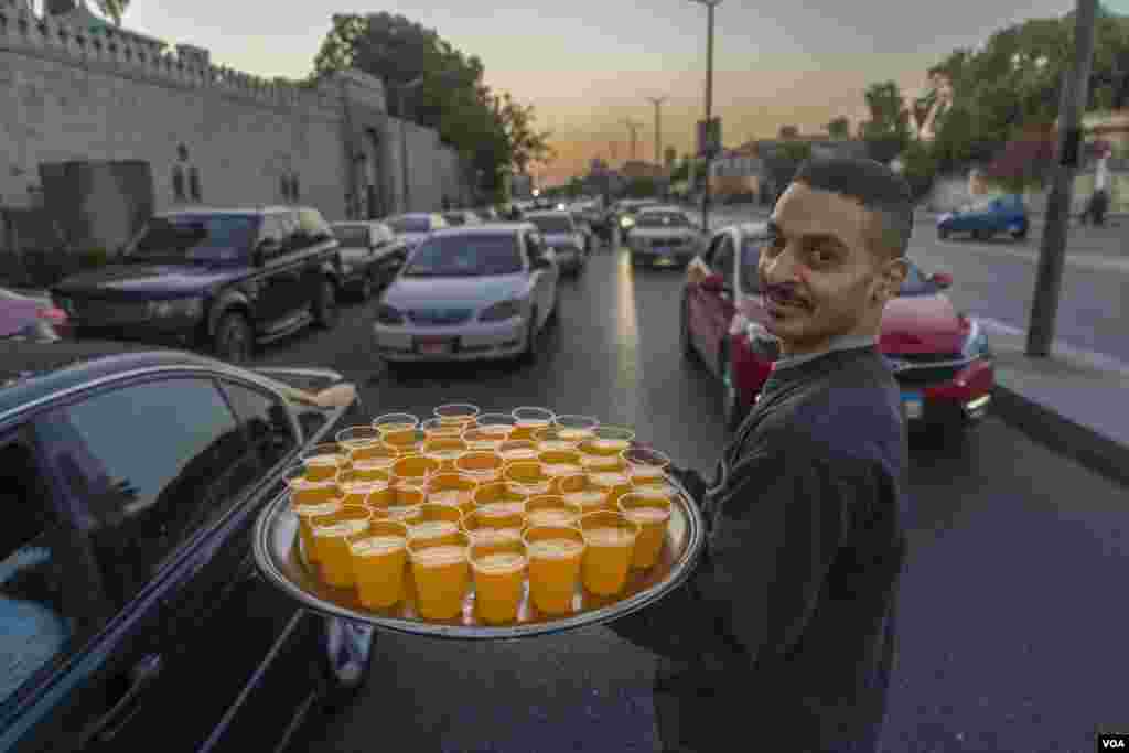 Reda, who serves free orange juice to Muslims breaking the fast, says, "Over the last two years, most people would refrain from taking juice from us if we weren't wearing masks or gloves—but now, nobody comments," in Cairo, April 23, 2022. (H. Elrasam/VOA)